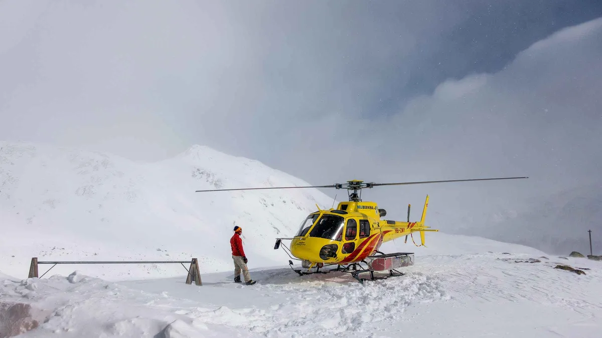 Yellow helicopter on a snowy landing pad on an Everest climbing tour with breakfast at the Everest View Hotel, Nepal