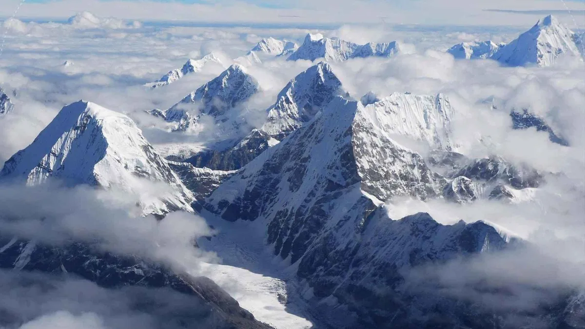 Himalayan peaks above the clouds from the plane on an Everest climbing tour by scenic mountain flight from Kathmandu, Nepal