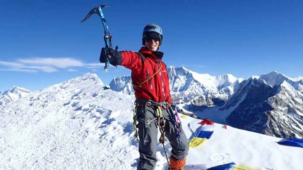 Climber raising an ice axe on a snow summit on an Everest climbing tour to Mera, Island and Lobuche peaks, Nepal